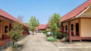 a street of houses with trees and a driveway at Sinsawat Resort in Uttaradit