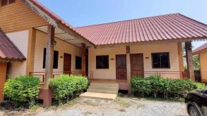 a house with a red roof and a porch at Sinsawat Resort in Uttaradit