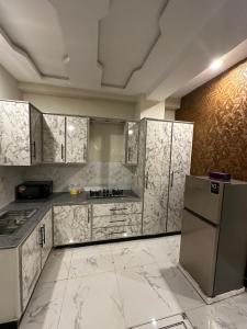a kitchen with white marble counters and a refrigerator at Two Bed Appartment in Islamabad