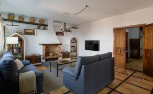 a living room with two blue couches and a fireplace at Casa Crisana in Haría