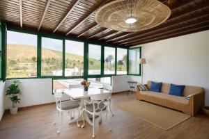 a living room with a table and chairs and a couch at Casa Crisana in Haría