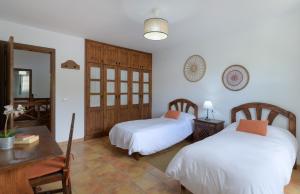 a bedroom with two beds and a desk and a table at Casa Crisana in Haría