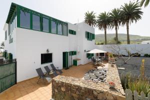a white house with a patio with a stone wall at Casa Crisana in Haría