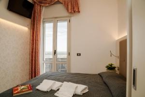 a bedroom with a bed with towels on it at B&B Metropols Sottomarina in Sottomarina