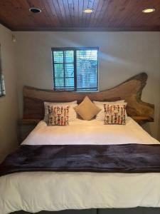 a bedroom with a large bed with a wooden headboard at The Rock & Root Guesthouse Self Catering in Nelspruit +41 photos