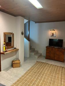 a room with a staircase and a television and a dresser at The Rock & Root Guesthouse Self Catering in Nelspruit