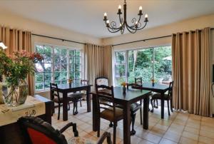 a dining room with a table and chairs and windows at Bancroft B&B in Hilton