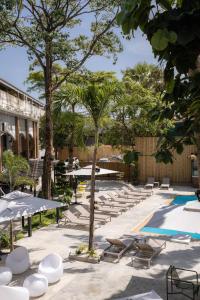 a courtyard with lounge chairs and a swimming pool at Aloha Tropicana Samui in Chaweng