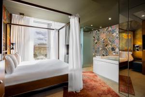 a bedroom with a bed with a window and a tub at Hotel SB Glow 4 Sup in Barcelona +40 photos