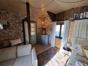 a living room with a couch and a stone wall at Chatka U Vlka in Lnáře