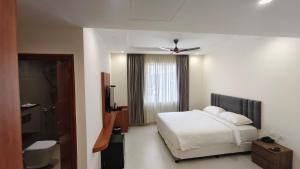 a bedroom with a bed and a ceiling fan at Darling Grand SME in Vellore