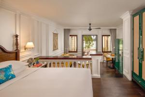 a bedroom with a bed and a living room at Anantara Hoi An Resort in Hoi An +82 photos