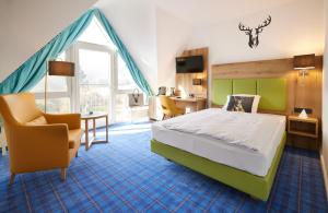 a hotel room with a bed and a chair at Waldhotel Bärenstein in Horn-Bad Meinberg