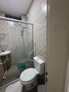 a bathroom with a toilet and a glass shower at Studio perfeito para trabalho, concurso ou compras in João Pessoa