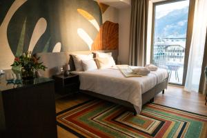 a bedroom with a bed and a large window at Hotel DAS SAAL in Saalfelden am Steinernen Meer +99 photos
