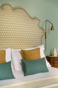 a bed with a large headboard and some pillows at Hotel Riva in Venice