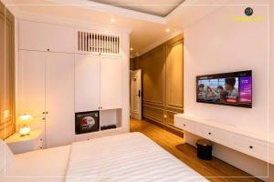 a bedroom with a bed and a tv on a wall at Harmony Hotel Nam Định in Như Thức