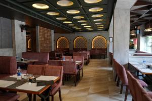 a dining room with tables and chairs and lights at Nesma Palace in Kannur