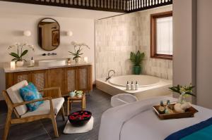 a bathroom with a tub and a sink and a bath tub at Anantara Hoi An Resort in Hoi An