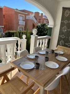 a wooden table with plates and glasses on a balcony at Casa Verde 56 in Cumbre del Sol +21 photos