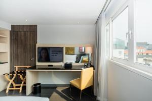 a desk with a computer in a room with a window at Garner Hotel Pattaya Central by IHG in Pattaya
