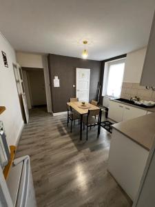 a kitchen and dining room with a table and chairs at Appartement au 1 er étage côté jardin in Thaon-les-Vosges