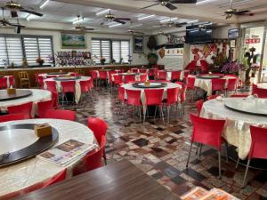 a restaurant with tables and chairs and red chairs at Country Homestay in Guoxing