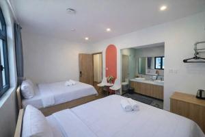 a hotel room with two beds and a bathroom at RosyDiamond Hotel Ocean Park 2 in Hòa Bình +28 photos