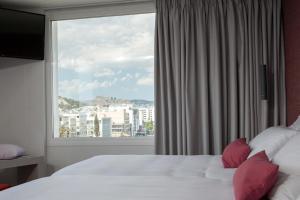 a bedroom with a large window with a view of a city at Athenaeum Smart Hotel in Athens +32 photos