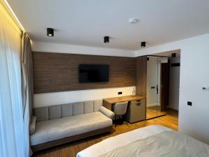 a bedroom with a couch and a desk and a tv at Sidharta Resort in Obarsia-Lotrului +35 photos