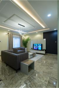 a living room with a couch and a tv at Sanctum Suites in Abuja