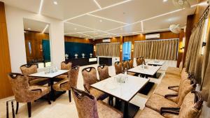a restaurant with tables and chairs in a room at Hotel Roop Cliff, Bhopal in Bhopal