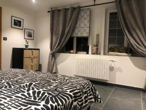 a bedroom with a black and white bed and a window at Lilas in Huelgoat