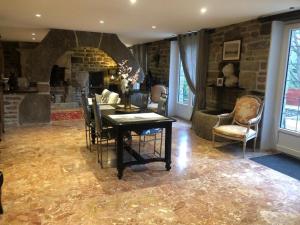 a living room with a table and a stone wall at Lilas in Huelgoat +1 photo