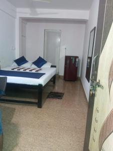 a bedroom with a bed with blue pillows at JBL Guest House , Arombal , Goa in Arambol