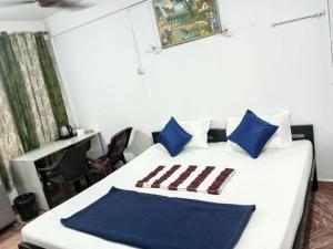 a bedroom with a bed with blue and white pillows at JBL Guest House , Arombal , Goa in Arambol +4 photos