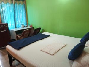 a bedroom with a bed with a table and chairs at JBL Guest House , Arombal , Goa in Arambol