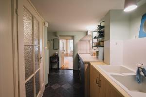 a small kitchen with a sink and a door at Appartement de vacances Papillon Stilvoll wohnen im Herzen der historischen Altstadt von Porrentruy in Porrentruy
