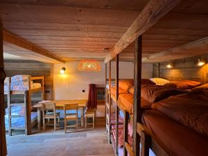 a room with bunk beds and a dining room with a table at Les Chryolles -Les Petits loups in Valmeinier