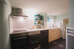 a small kitchen with a sink and a stove at Appartement de vacances Papillon Stilvoll wohnen im Herzen der historischen Altstadt von Porrentruy in Porrentruy +17 photos