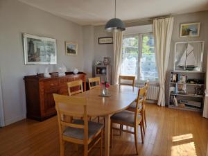 a dining room with a wooden table and chairs at ST MARTIN PLAGE in Saint-Martin-Plage