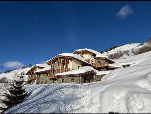 a large building covered in snow on a mountain at Les Chryolles -Les Petits loups in Valmeinier