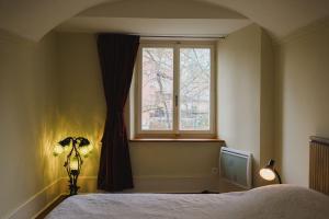 a bedroom with a bed and a window at Appartement de vacances Papillon Stilvoll wohnen im Herzen der historischen Altstadt von Porrentruy in Porrentruy