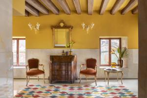 a living room with two chairs and a table and a mirror at Hotel Riva in Venice