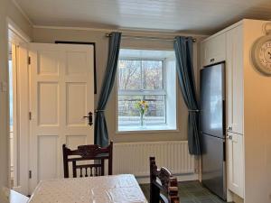 a kitchen with a door and a window and a table at Cottage 496 - Leenane in Leenaun
