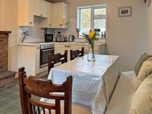 a kitchen with a table with a vase of flowers on it at Cottage 496 - Leenane in Leenaun