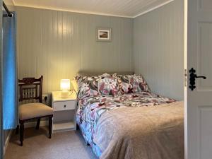 a bedroom with a bed and a table and a chair at Cottage 496 - Leenane in Leenaun
