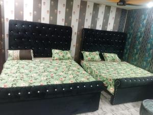 a bedroom with a bed and a bed and a couch at Al Shahzan Hotel in Lahore +2 photos