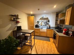 a kitchen with wooden cabinets and a table in it at Advent House Ancoats Hosted Apartment in Manchester