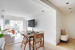 a living room with a table and a couch at Charming Apt with AC & balcony in Suresnes